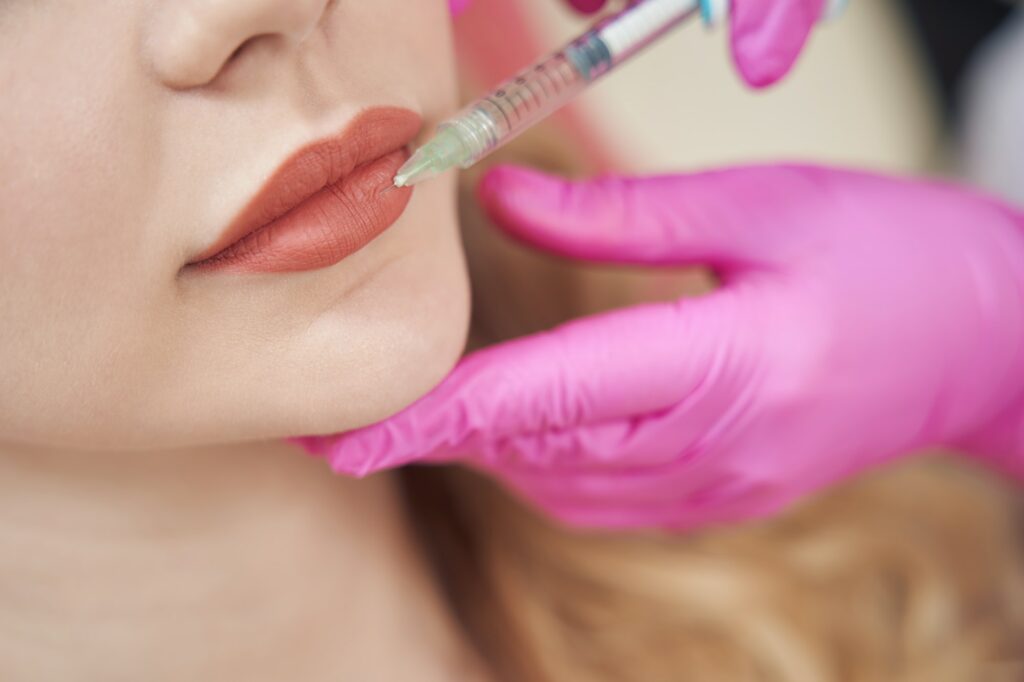 Charming lady getting beauty hyaluronic lip injection in medical center